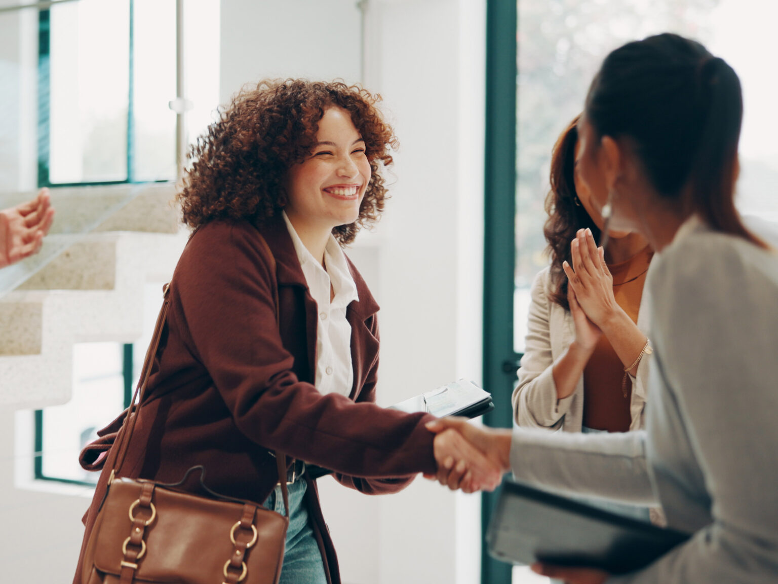 Employees, women and happy at office with handshake for recruitment, welcome and agreement. Business, people and smile or applause for job well done, promotion and career opportunity at meeting